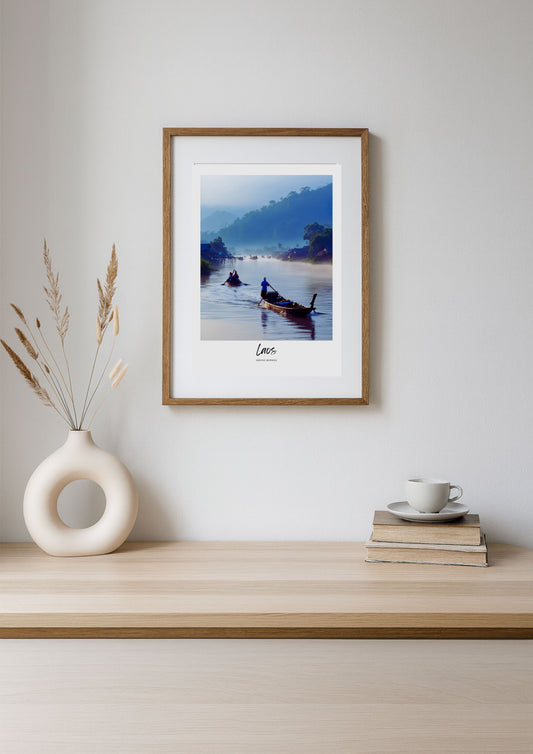 Framed photograph of a scenic landscape with a boat on a lake, displayed on a wooden shelf.