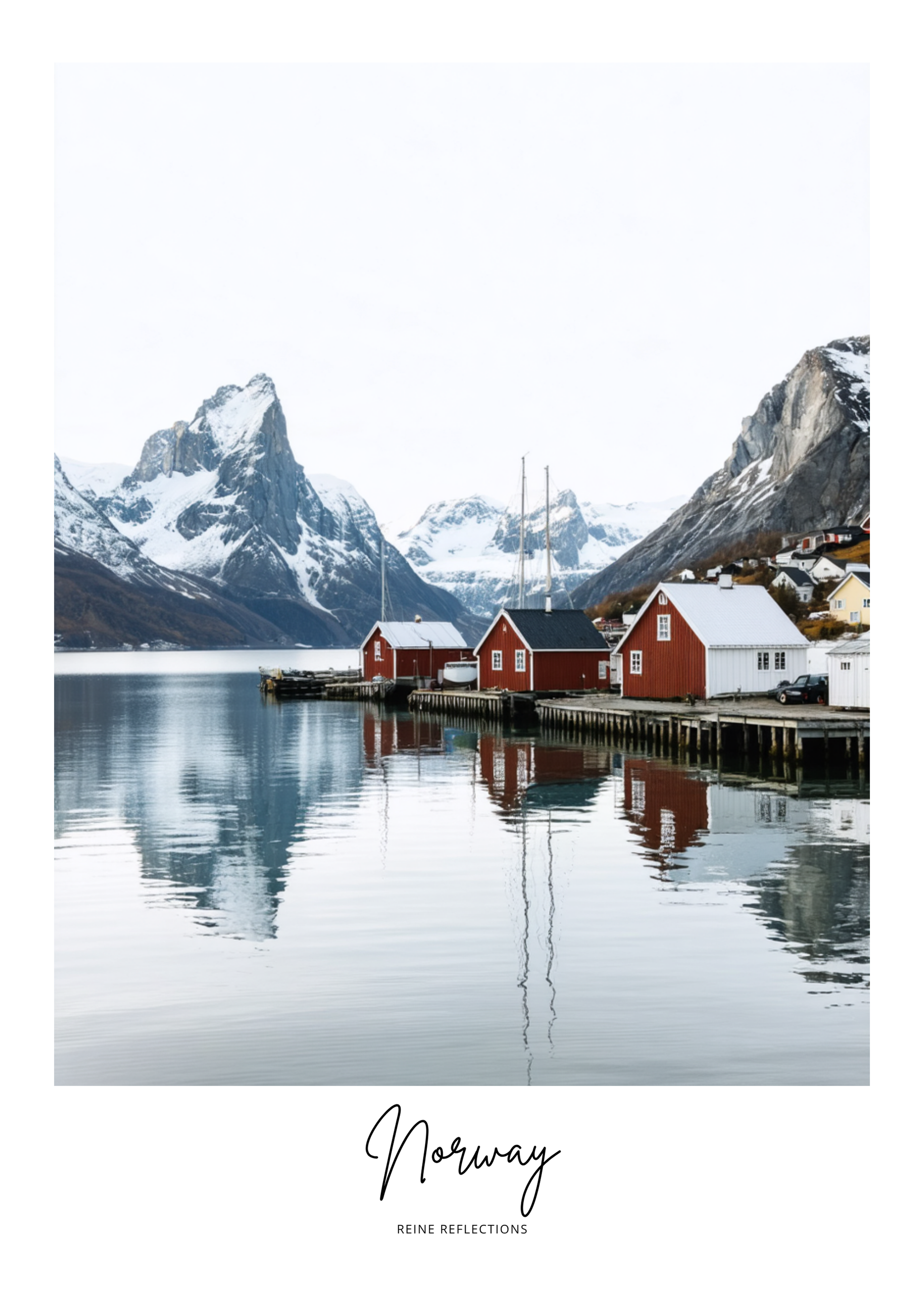 Scenic view of a fjord with red cabins and snow-capped mountains in Norway.