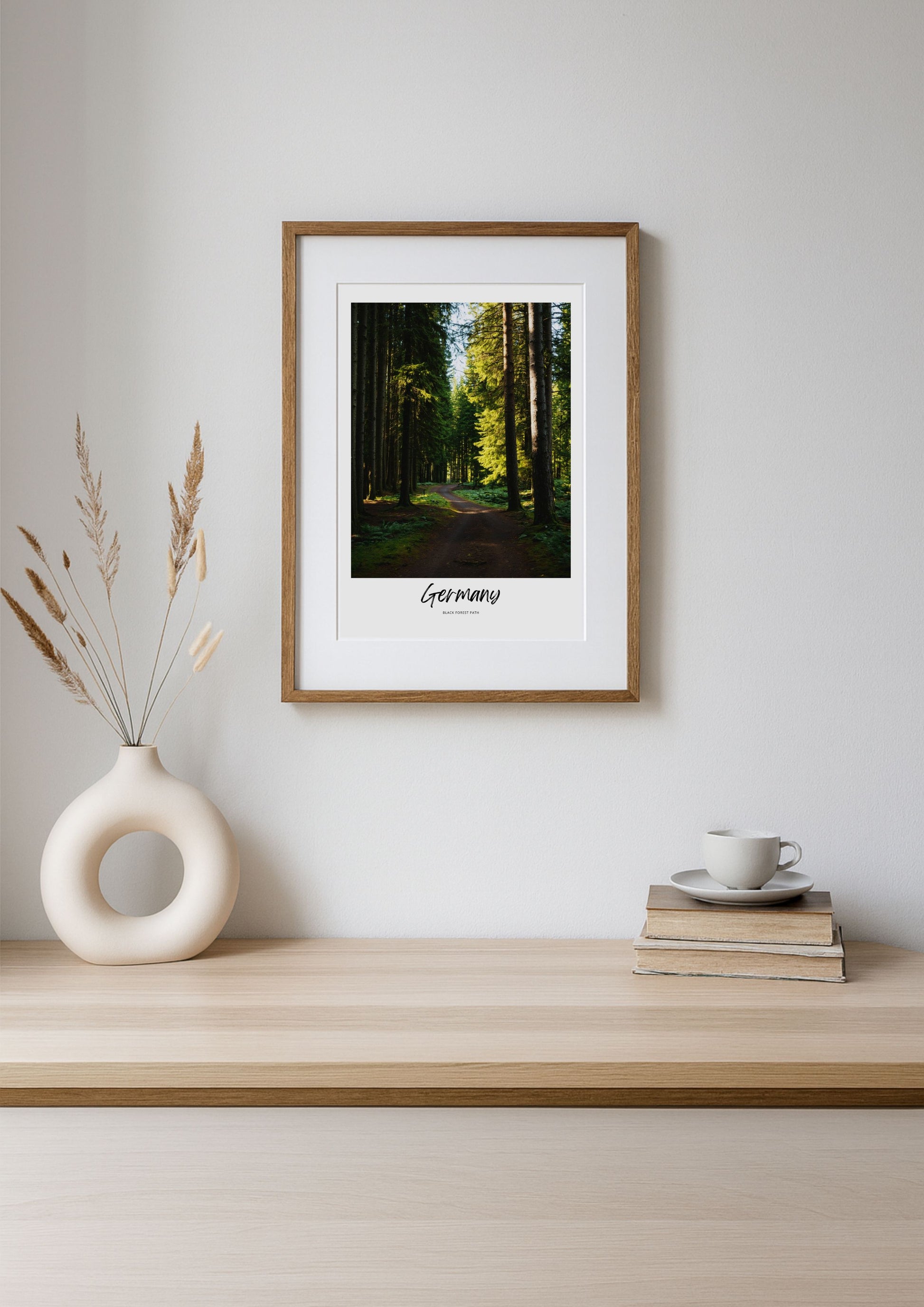 Framed print of a forest scene on a wooden shelf with decor items.