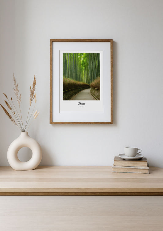 Framed print of a bamboo forest on a wall above a wooden shelf with decor items.